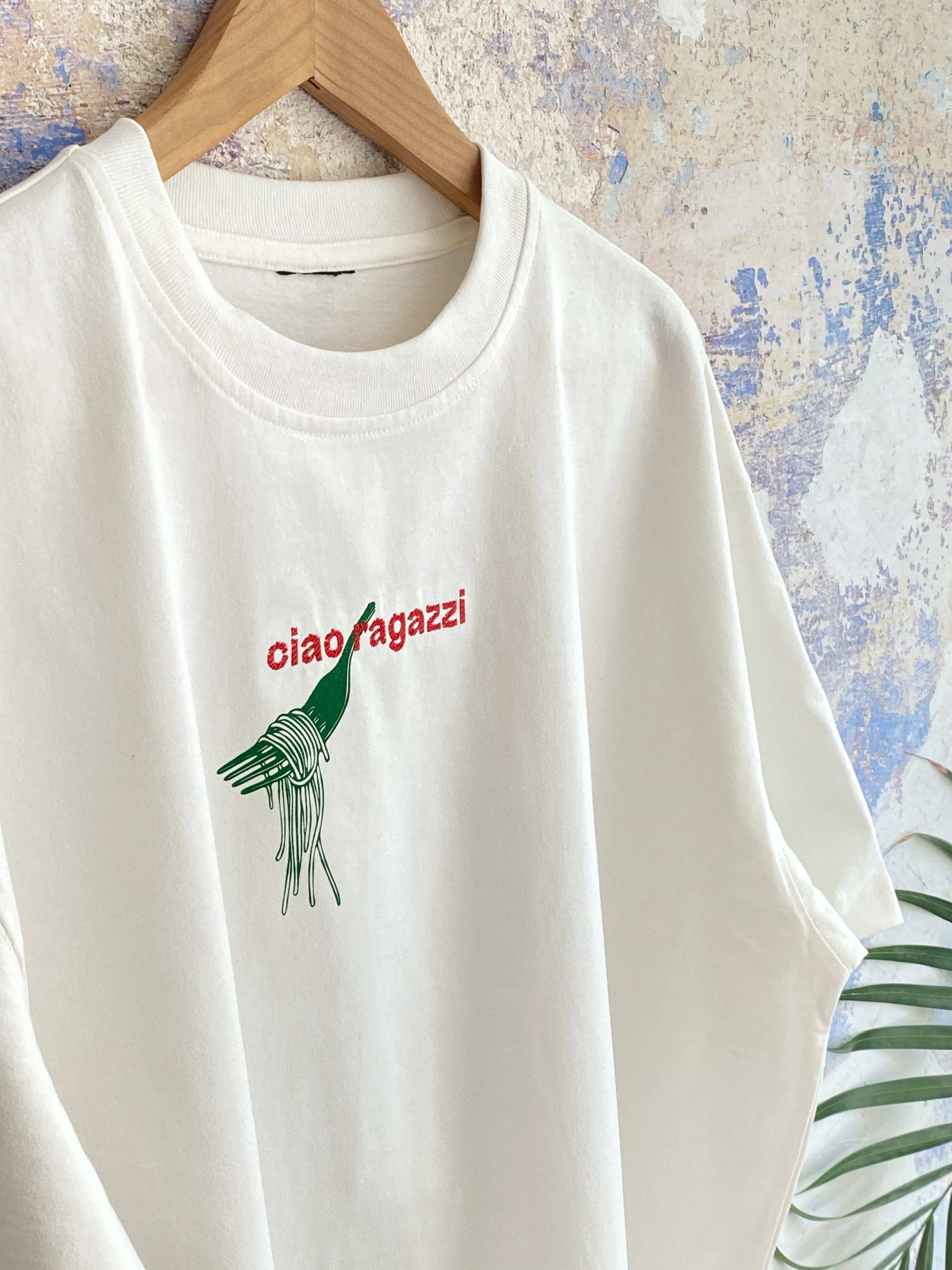 T-Shirt mit typografischem Schriftzug „ciao ragazzi“ und Pasta-Motiv als Kombination aus Stickerei und Siebdruck